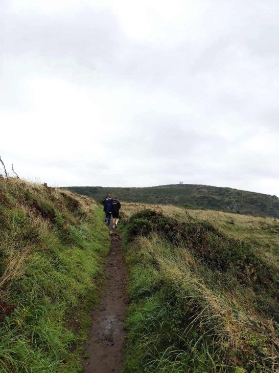 Walkers on a muddy coast path