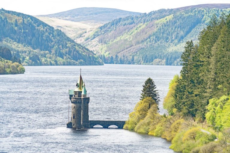 Llyn Vyrnwy Lake, looking across the lake to the mountains behind, with the stone tower in the middle of the picture. 