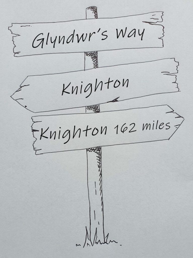 Hand drawn sign post showing Glyndwr's Way, Knighton to Welshpool 135 miles 