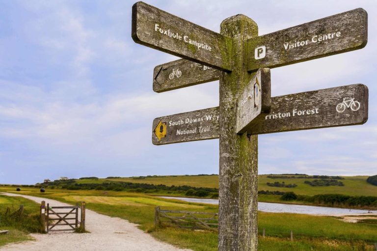 Wooden sign post showing six directions on South Downs Way