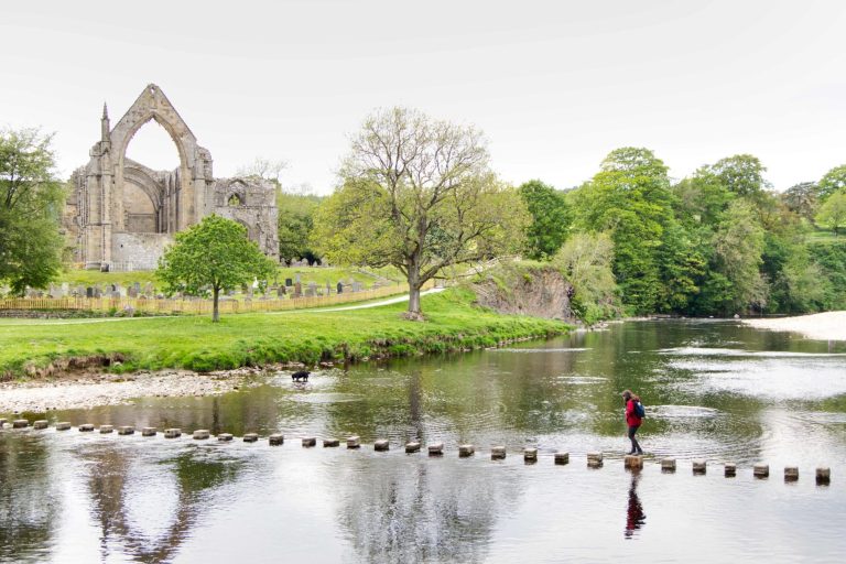 Crossing stepping stones over the river at Bolton Abbey