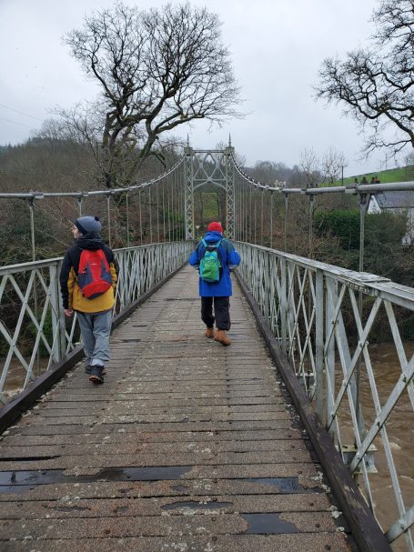 Walkers walking over bridge at Erwood