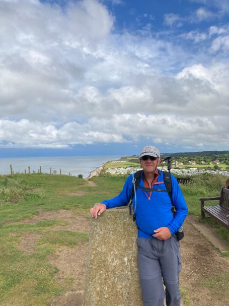 Walker at Beeston Bump, the highest point of the Norfolk coast path